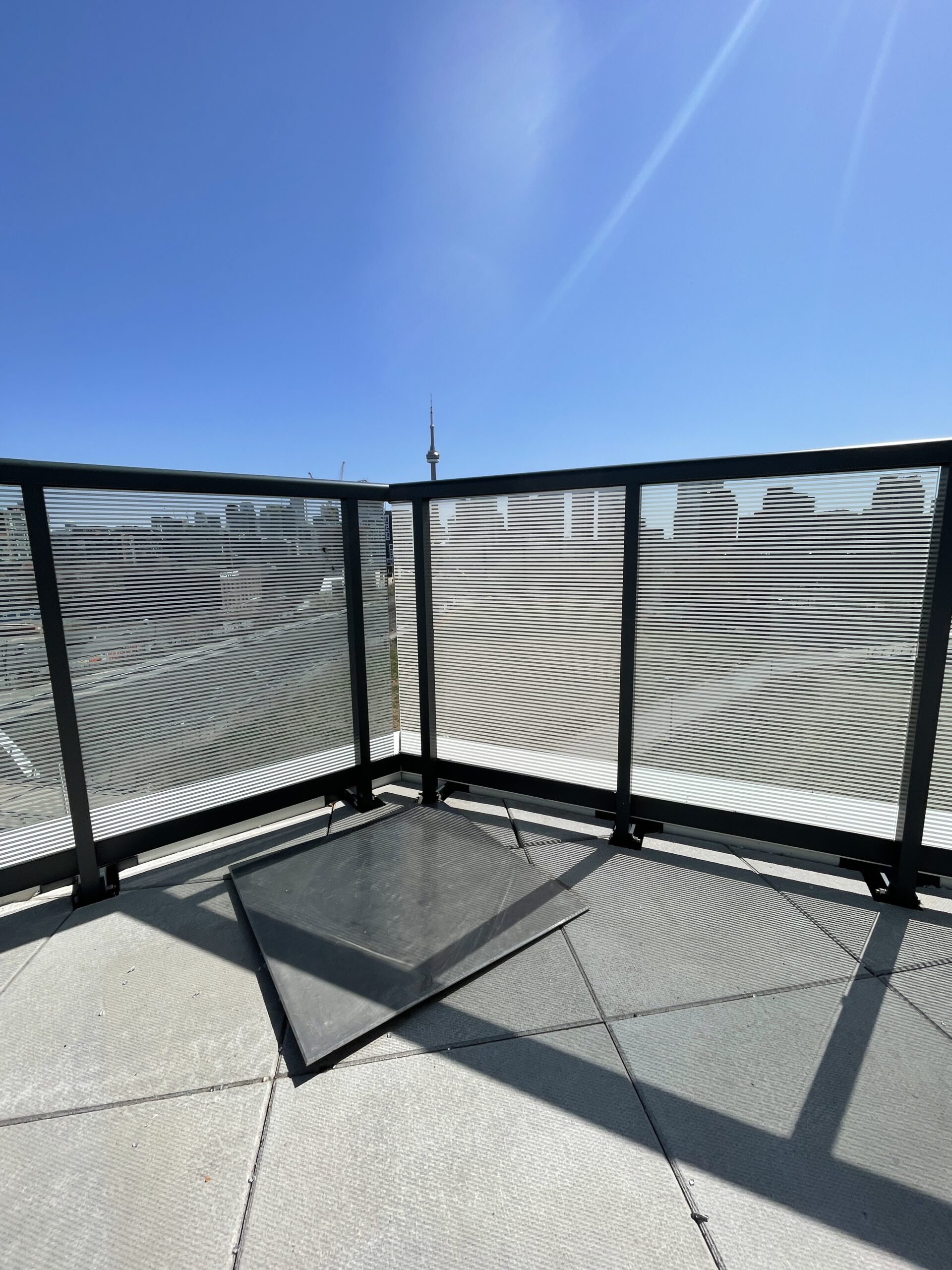 Modern balcony with waterproofed flooring and sturdy railings overlooking a city skyline, showcasing professional balcony waterproofing and repair.